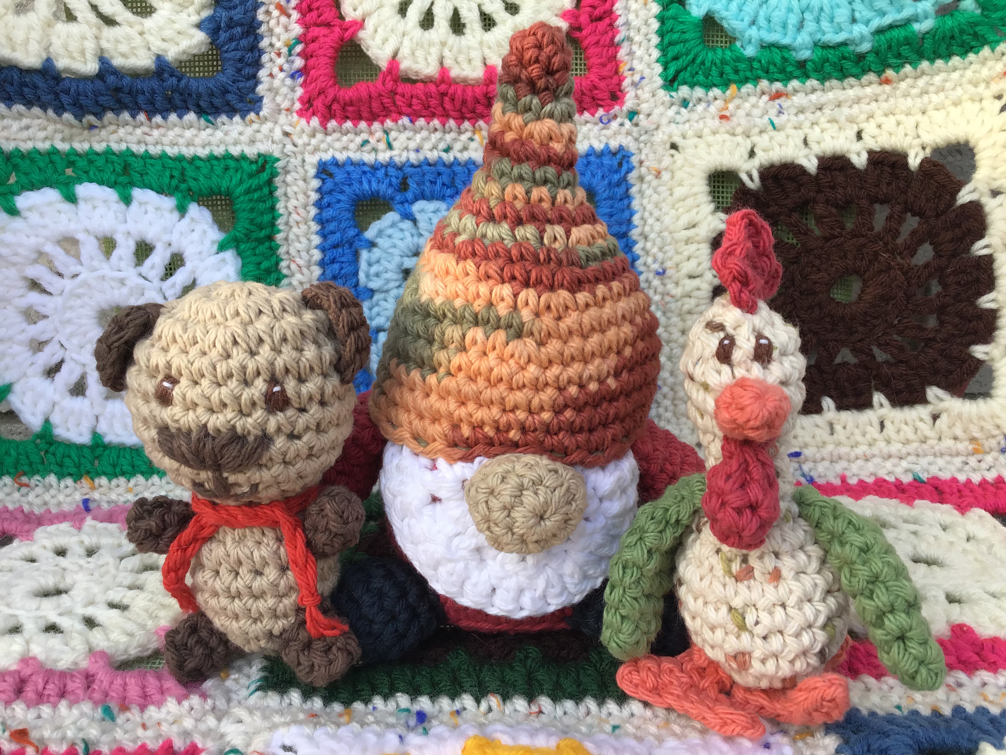 Tiny teddy, medium gnome, and tiny rooster crocheted stuffed toys