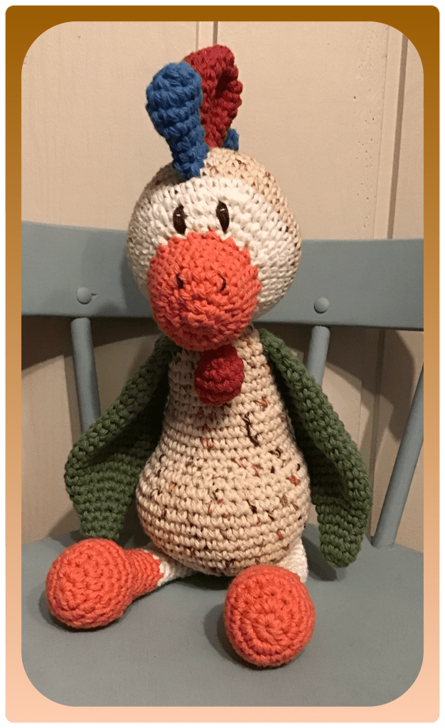 Rooster stuffed animal sitting on a chair