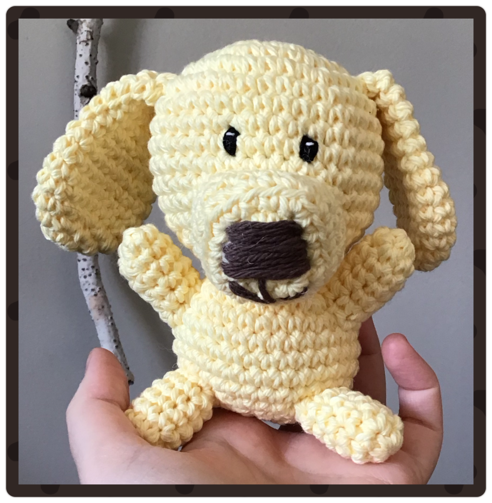 A medium sized floppy eared puppy. This is my own pattern. This pup is yellow and being held up to the camera