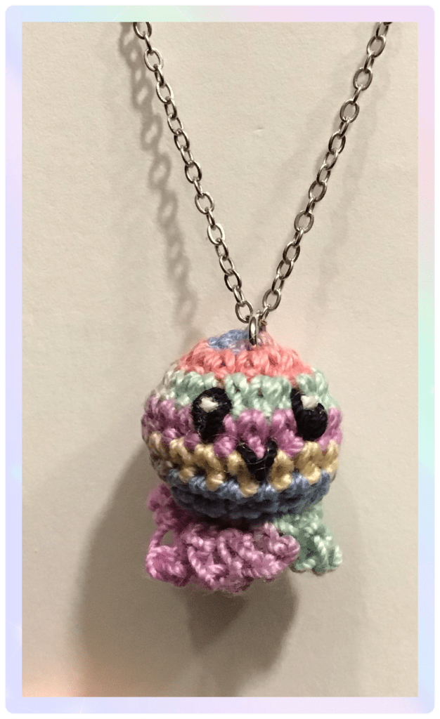Necklace with micro crochet octopus in muted rainbow colours