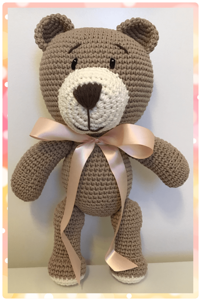 Teddy bear in jute and soft cream with a pale pink ribbon