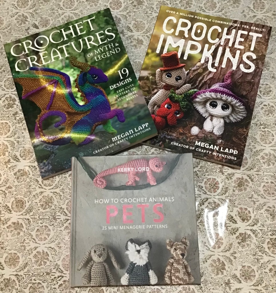 Picture of the 3 pattern books. Left to right, top to bottom, "Crochet Creatures of myth and legend" and "Crochet Impkins" both by Megan Lapp. The 3rd is "How to crochet animals Pets" by Kerry Lord.