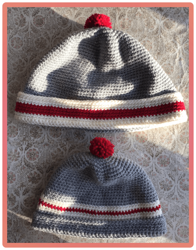 This picture has 2 sizes of sock monkey tuques in it.